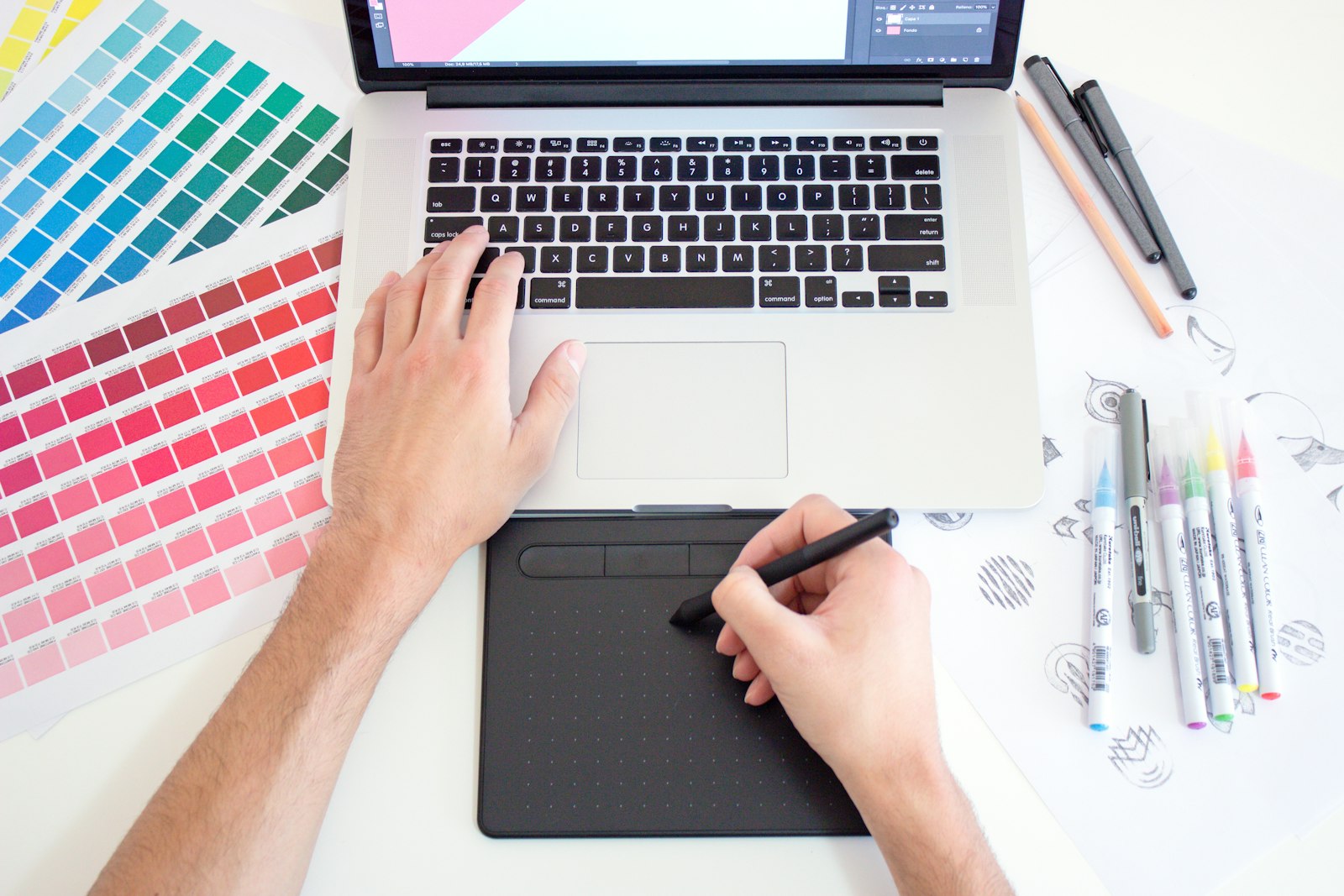 Une designer travaille sur des nuanciers de couleurs et une tablette graphique