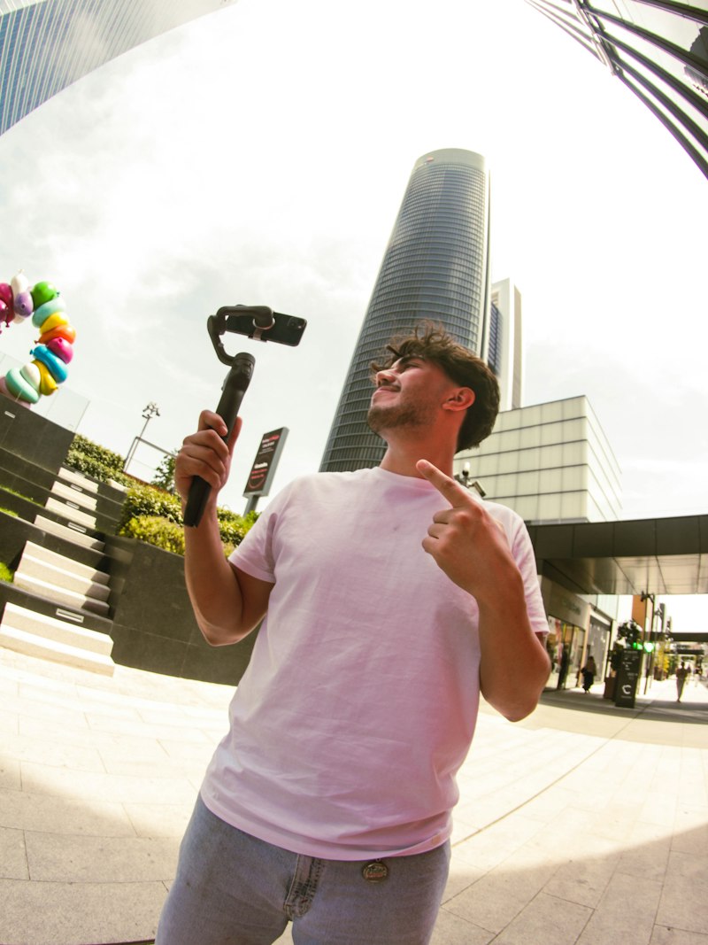 Un créateur filme une vidéo verticale avec un téléphone sur stabilisateur en ville